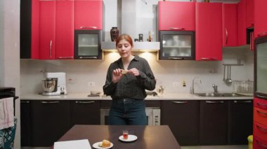 Evinin Mutfağında Kurabiye yerken Dans Eden ve Şarkı Söyleyen Bir Kadın.