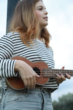 Mutlu kız doğada gitar çalıyor..