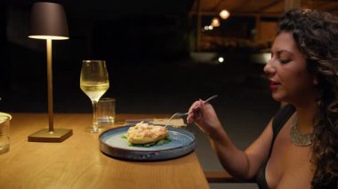 Restoran masasına yeni gelen tabaktan bahseden bir kadın. . 