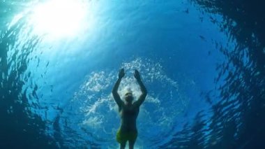 Erkek yüzücü gölde kurbağalama eğitimi alıyor. Suyun altından görülüyor. . 