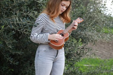 Mutlu kız doğada gitar çalıyor..