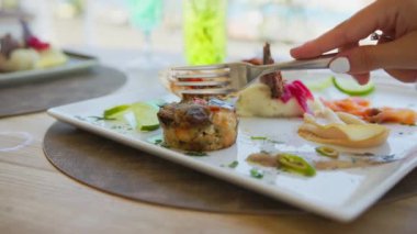 Aperatif tabağının içinde küçük bir balık keki kesiyorum. . 