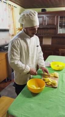 Ev aşçısı patatesleri masada kızartmak için keser..