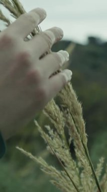 Bulutlu bir günde kırsalda pelerinli genç bir kadın..