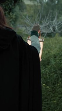 Bulutlu bir günde kırsalda pelerinli genç bir kadın..