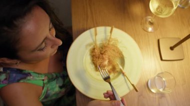 Restoranda yemek yiyen bir kadın için rahatlatıcı ve sıcak bir ışık. . 