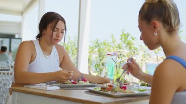 Sahilde öğle yemeği yiyen iki arkadaş gurme balık yiyor. . 