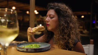 Restoranda akşam yemeğinde özel bir çeşit kızarmış pizza yiyen bir kadın. . 