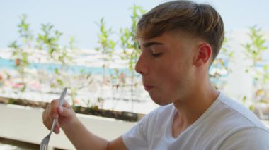 Genç adam, restorandaki gurme tabağını yavaşça yiyor ve kaydediyordu. .