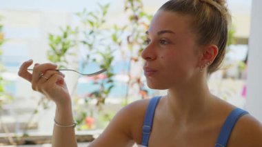 Plajda öğle yemeği sırasında taze somon yiyen bir kadın. . 