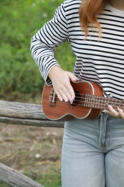 Mutlu kız doğada gitar çalıyor..