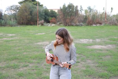 Mutlu kız doğada gitar çalıyor..