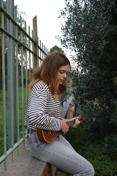 Mutlu kız doğada gitar çalıyor..