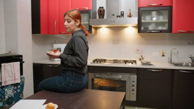 Masada oturan bir kadın lezzetli kurabiyeler yiyor..