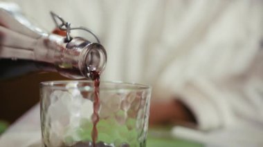Şişe Calabrian ev yapımı kırmızı şarabı cama döker.