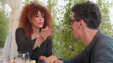 Bir kadın, balık tabağını sahil merkezindeki ortağıyla paylaşıyor. . 