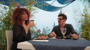 Sahildeki romantik yemek sırasında gülümse ve neşelen. .