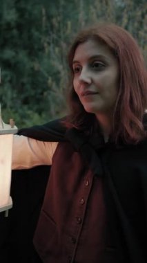 Bulutlu bir günde kırsalda pelerinli genç bir kadın..