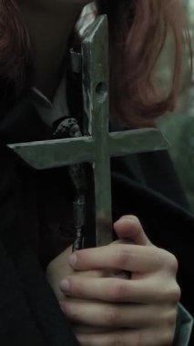 Bulutlu bir günde kırsalda pelerinli genç bir kadın..