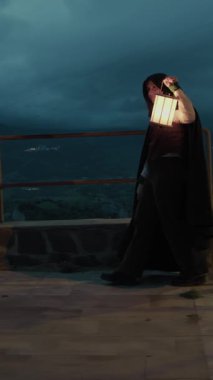 Bulutlu bir günde kırsalda pelerinli genç bir kadın..