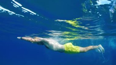 Vücudunun zindeliğini sağlamak için okyanusta yüzen bir adam. . 