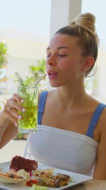 Plaj tatili sırasında kamışla taze bir kokteyl içen kadın. . 