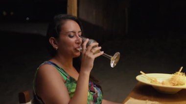 Restoran yemeğinde gülümseyen ve şarap içen bir kadın kendini mutlu hisseder. . 