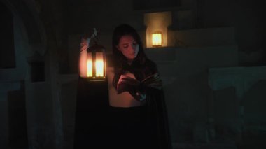 Gizemli genç kadın pelerin ve fenerle bir köyün sokaklarında yürüyor..