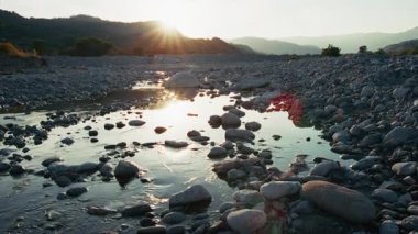 Zamanın geçişi, günbatımındaki nehrin yavaş akışına kıyasla.