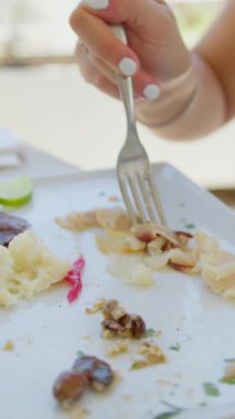 Güzel bir aperatifle öğle yemeğine başlayan bir kadın plaj otelinde yemek yiyor. . 