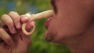 Yemek sırasında ahtapotu elleriyle yiyen bir adamın detayları. . 