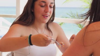 Yemek sırasında gülümseyen ve konuşan kadın. . 