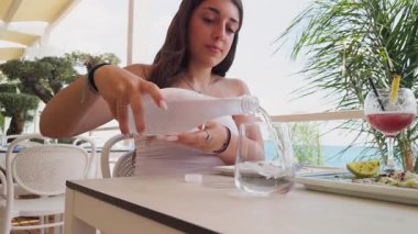 Öğle yemeğinde bardağın içine su dökülüyor. . 