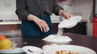 Genç Kadın, tipik bir tatlıyı hazırlamak için masayı una koyar..