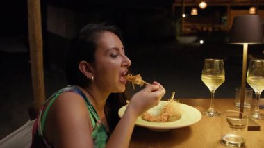 Sahilde akşam yemeği için karides yiyen bir kadın. . 