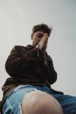 Adam kışın kıyıda tespih ve gözleriyle dua ediyor. . 