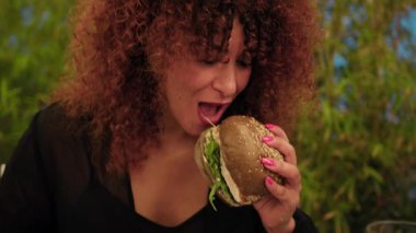 Tatil yemeği sırasında ton balıklı burger yiyen kadın. . 