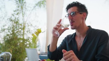 Plaj tatili sırasında arkadaşlarıyla tezahürat yapan ve içen bir adam..