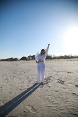 İtalyan Kız Beyaz Giysiler İçinde Okyanus 'un yanındaki yumuşak plajda Dans Ediyor .