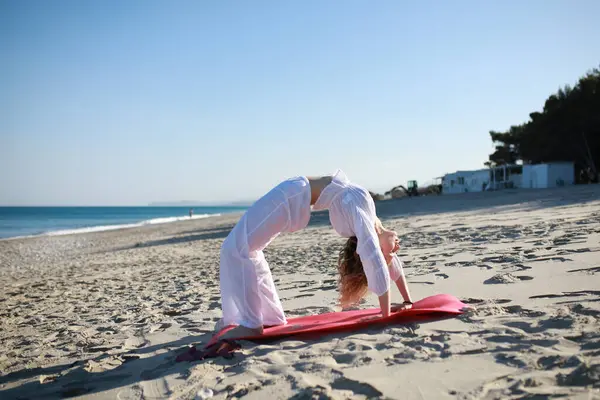 Genç kadın sahilde ters köprü spor salonuna hazırlanıyor. .
