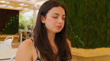 Rahatlamış ve mutlu bir kadın yemek yiyor. . 