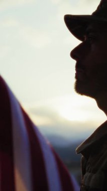 Anma Günü için gün batımında Amerikan Bayrağı önünde Bir Askerin Silüeti