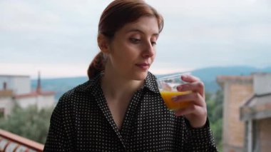 İtalyan kadın sabahları vitamin almak için portakal suyu içiyor. .