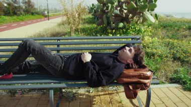 Doğada, deniz kenarında bir bankta dinlenen bir adam. . 