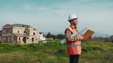 İnşaat alanındaki işçilere emirler veren gözden çıkarılmış mimar. .