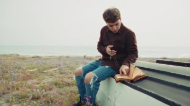 Hıristiyan adam sahildeyken İncil 'de dua okuyor. . 