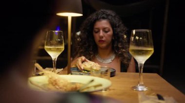 Restoranda akşam yemeği için gurme kızarmış pizzayı ısıran kadın. . 