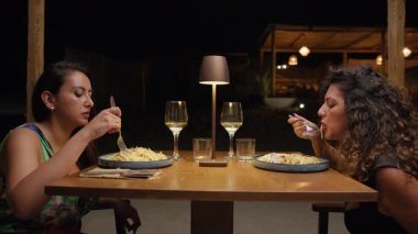 İki arkadaş yazın lokantada dışarıda yemek yiyorlar. . 