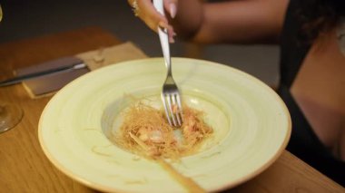 Akşam yemeğinde çatalı karides yemek için kullanan bir kadın. . 