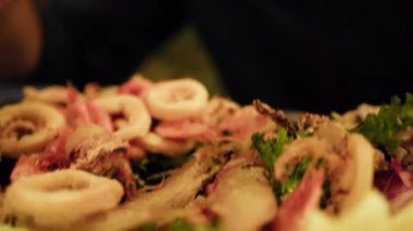 Restorandaki balık aperatifinden karides toplayan adam. . 